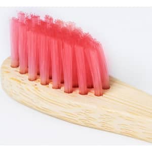 A bamboo toothbrush with bright pink bristles and a wooden handle. The product has a logo on it.