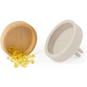 A ceramic air freshener with a plug design next to a bamboo container filled with yellow gel beads.