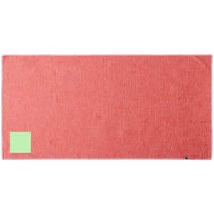 A red absorbent towel with a small green patch and a logo, suitable for leisure and outdoor activities.