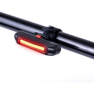 A red bike safety light mounted on a black bike frame, featuring a sleek design and a logo.