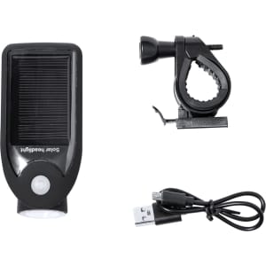 A solar-powered headlight with a black casing, a mounting clip, and a USB charging cable.