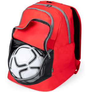 A red backpack with multiple compartments and a soccer ball partially visible in a mesh side pocket. It has branding on it.