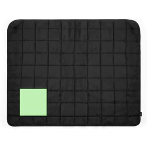 A black picnic blanket with a green square patch in one corner, featuring a quilted texture.
