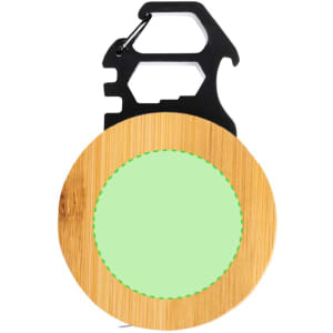 A bamboo tape measure with a green circular centre and a black multi-tool clip attachment.