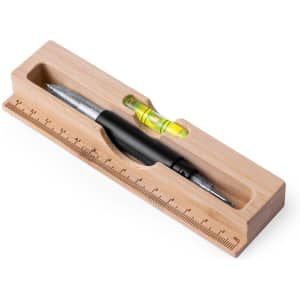 A bamboo desk organiser containing a black pen, a spirit level, and a ruler. It features a sleek, natural finish.
