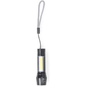 A black torch with a silver lanyard, featuring a bright LED light and a textured grip. It has a logo on the body.