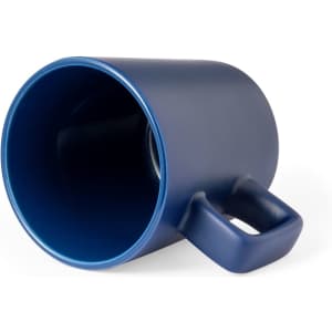 A blue ceramic coffee mug with a unique handle design, featuring a smooth matte finish and a brand logo.