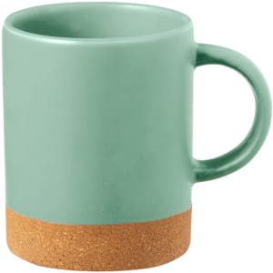 A green ceramic coffee mug with a cork base and a sturdy handle. It features a simple, modern design.