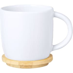 A coffee mug in white with a bamboo coaster. Simple design with a curved handle and smooth finish.