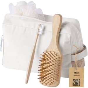 A cream toiletry bag containing a wooden hairbrush, a bamboo toothbrush, and a shower loofah.
