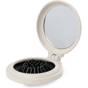 A compact hairbrush with a mirror, featuring a beige outer case and black bristles inside.