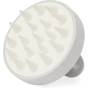 A circular hair scalp massager in grey with white rubber spikes for stimulating the scalp. It features a handle for grip.