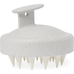 A grey scalp massager with a soft grip handle and pointed bristles for hair care. It features a textured surface.