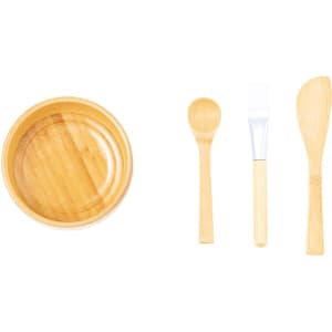A bamboo bowl with three wooden utensils, including a spoon, spatula, and small scoop.