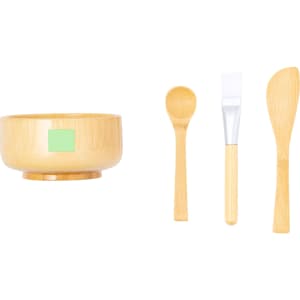 A bamboo bowl and three wooden utensils: a spoon, a spatula, and a flat paddle, all in natural tones.