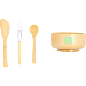 A bamboo bowl set featuring a scoop, spatula, and brush, showcasing natural wood tones. The bowl includes a small logo.