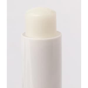 A white lip balm in a cylindrical container, featuring a smooth, rounded top. The product has branding on the packaging.