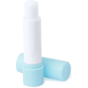 A vegan lip balm in a sleek white and light blue tube, lying on a flat surface with the cap removed.