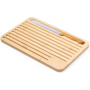 A bamboo chopping board with grooves, featuring a knife with a wooden handle. It has a sleek design and a natural finish.