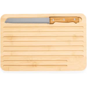 A bamboo cutting board with a serrated knife resting on it, featuring a natural wood finish and grooves.