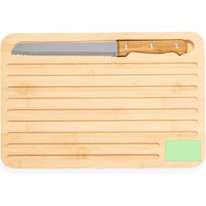 A bamboo cutting board with a serrated knife, featuring a green section and grooves for food preparation.