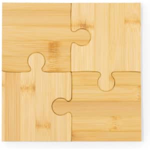 A bamboo coaster set featuring four interlocking puzzle pieces in a natural finish. It has a simple, modern design.