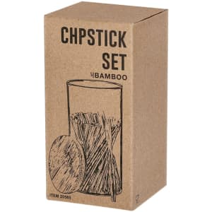 A chopstick set in a kraft box, featuring bamboo chopsticks and a round holder. The packaging has a simple design.