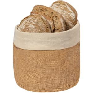 A natural jute bread basket with a cream-coloured fabric rim, holding several loaves of bread.