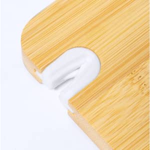 A bamboo cutting board featuring a white sharpener integrated into its edge. It has a smooth finish and rounded corners.