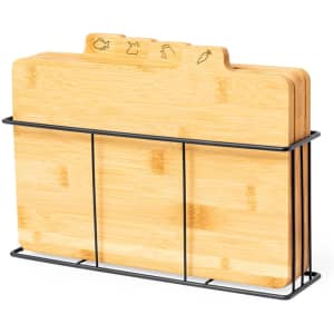 A set of bamboo chopping boards in a metal stand, featuring carved icons for different food types.