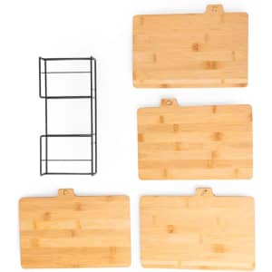A set of four bamboo cutting boards in various sizes, accompanied by a black storage rack.