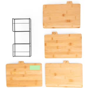 A set of four bamboo cutting boards in various sizes with a black metal storage rack.