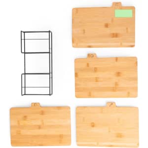 A set of four bamboo cutting boards in various sizes, accompanied by a black metal storage rack.