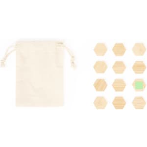 A canvas drawstring bag alongside a set of twelve wooden hexagonal magnets, one featuring a green accent.
