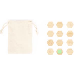 A cream drawstring bag beside a set of twelve hexagonal wooden magnets, featuring one magnet in light green.