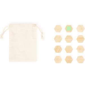 A small beige drawstring bag beside a set of twelve natural wooden hexagonal magnets, one featuring a green accent.