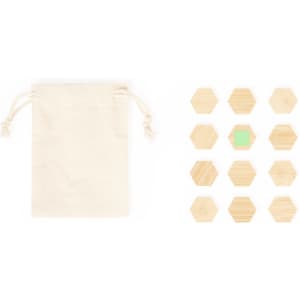 A cotton pouch alongside wooden hexagonal magnets, including one green magnet, arranged on a light surface.