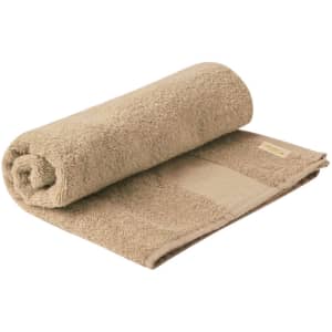A rolled beige hand towel with a textured surface, featuring a subtle branding label.
