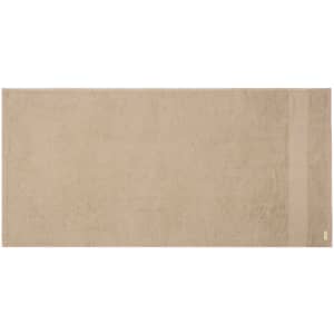 A beige hand towel with a textured surface and a discreet logo on one side.