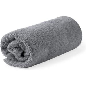 A rolled grey towel, featuring a soft and fluffy texture, with a visible logo on the fabric.