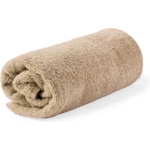 A soft, rolled beige towel with a fluffy texture, featuring a branding logo.