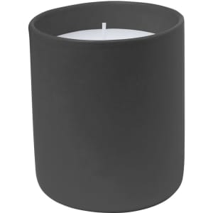 A matte black candle holder containing a white candle, with a simple, modern design. It features a branding logo.