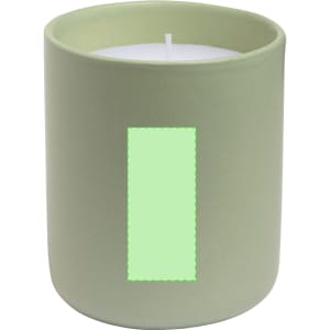 A green ceramic candle holder with a white candle inside, featuring an empty rectangular label.