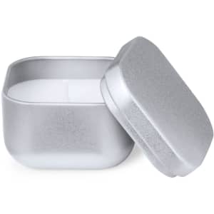 A silver, square tin with a removable lid containing a white aromatic candle inside.