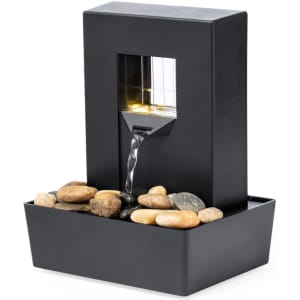A black indoor water fountain featuring a sleek design, flowing water, and decorative stones in the base.