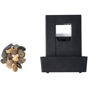 A black water fountain with a square design and a collection of small, smooth pebbles beside it.