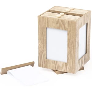 A wooden photo frame in light oak finish with a slot for photos and a removable base for easy access.