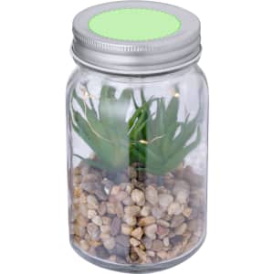 A decorative plant in a clear jar with pebbles, featuring green artificial leaves and a silver lid.