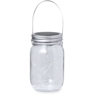 A clear glass lamp with a silver lid and handle, featuring decorative lights inside.