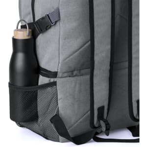 A drink bottle rests in a mesh pocket of a grey backpack designed as a cooler bag. The bag has adjustable straps.